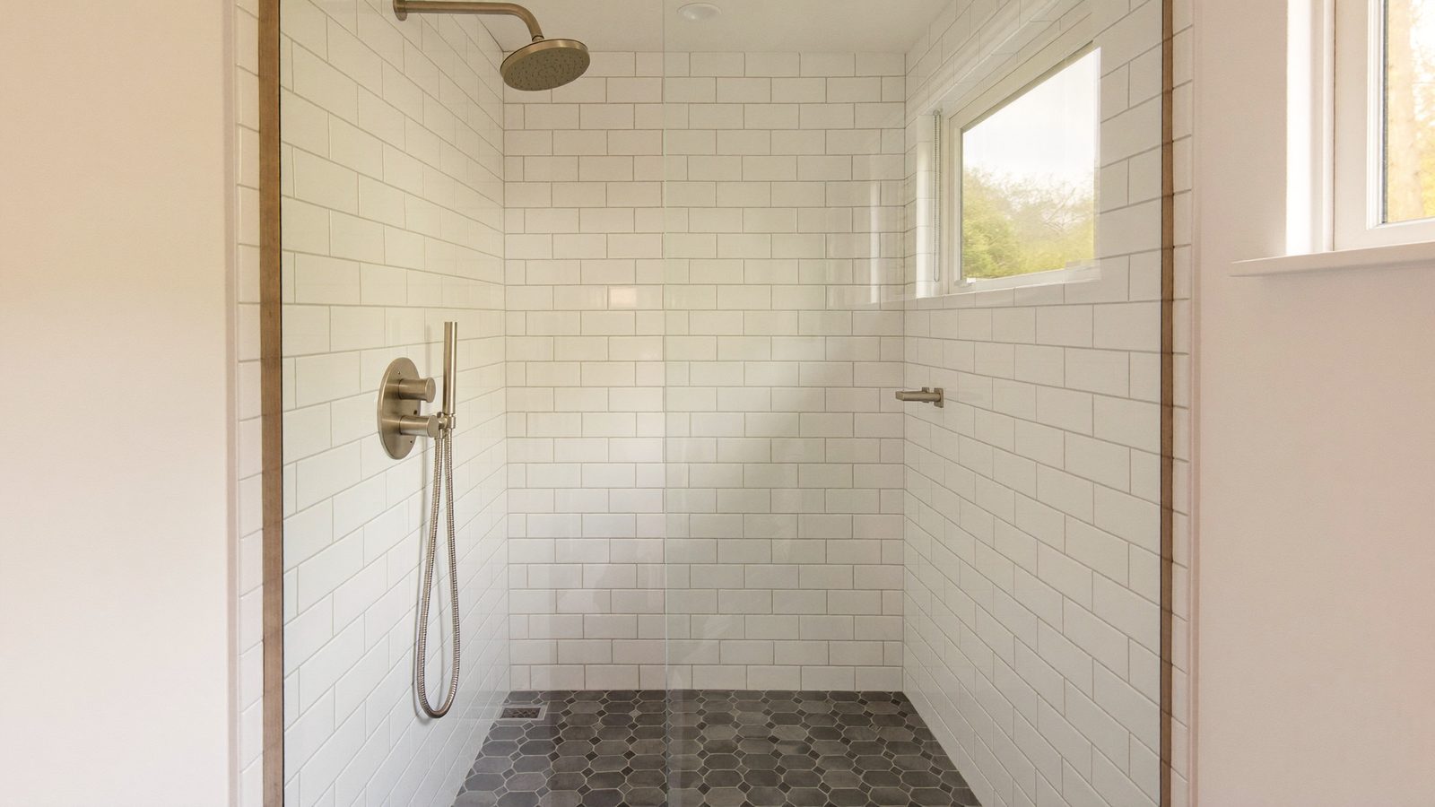 Walk-in shower with glossy wall tile and matte floor tile