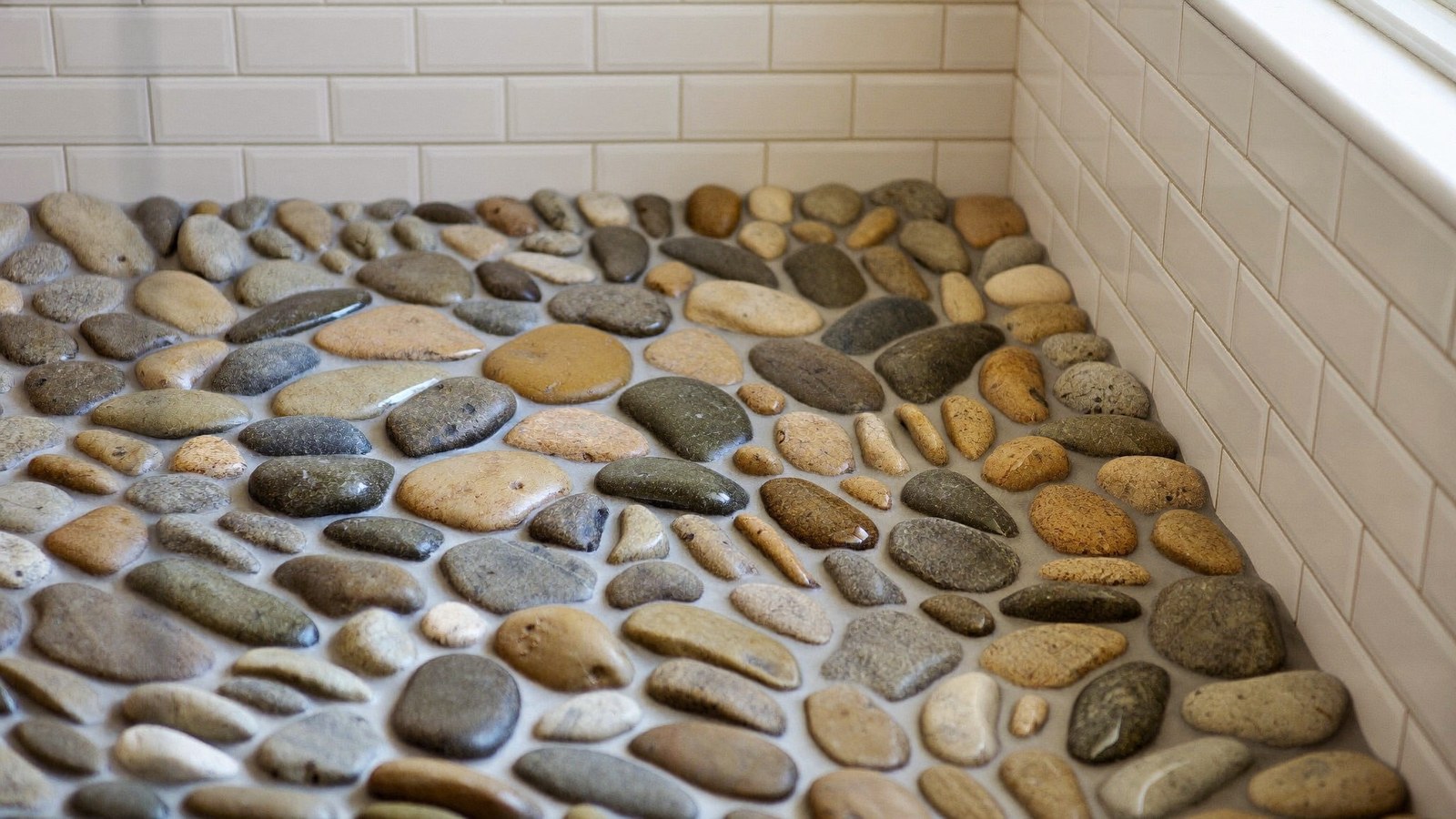 Pebble tile shower floor with grout between the stones