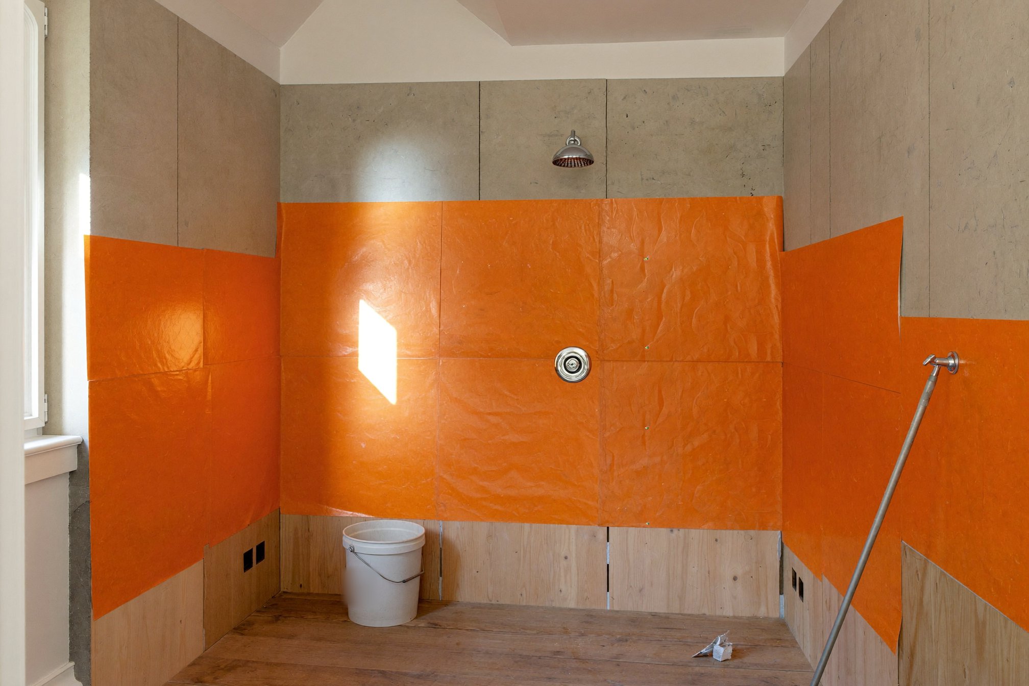Shower wall covered with a waterproof membrane before tile installation